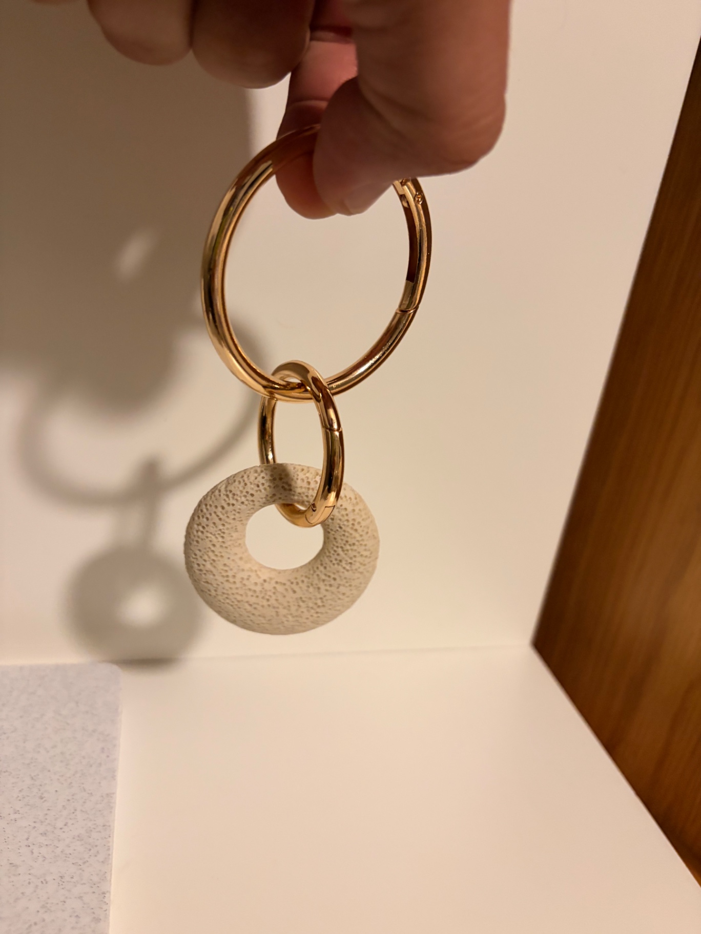 Mine Círculo Bone White sostenido en mano con Oro Sereno